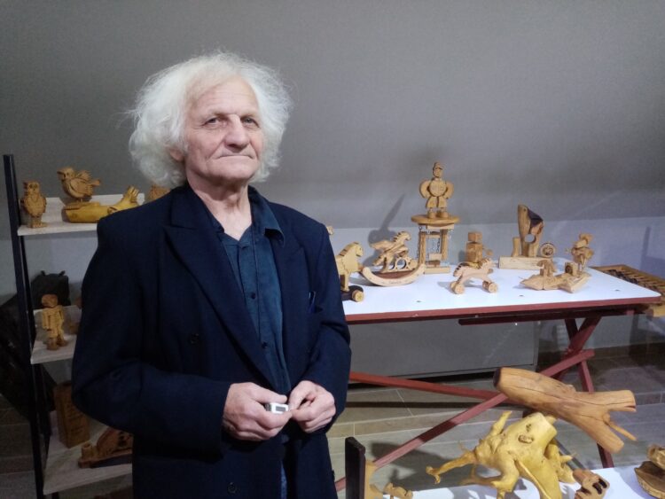 Ján Žolnaj st. pri svojich drevených hračkách a dekoračných predmetoch