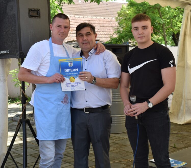 Ján Bartoš vyrobil najkvalitnejšiu údenú klobásu; na fotografii s petrovským richtárom Jánom Lačokom a moderátorom Milanom Hemelom