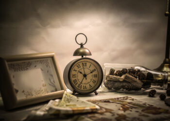 Alarm clock and bottle on the desktop