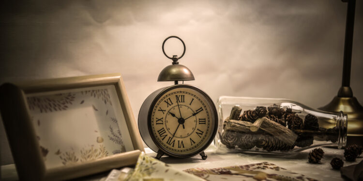 Alarm clock and bottle on the desktop