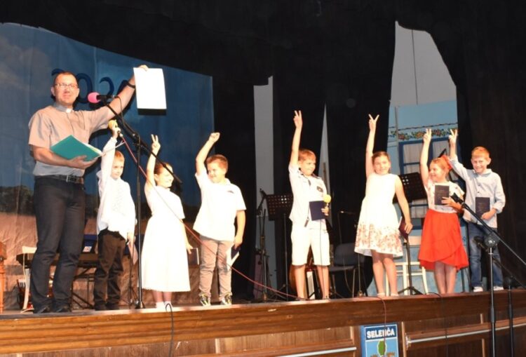 Poďakovanie za školský a katechetický rok: žiaci a farár z tamojšej katolíckej farnosti