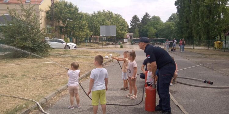 Hasiči s deťmi pri rýchlom cvičení s vodou a tzv. brentačmi